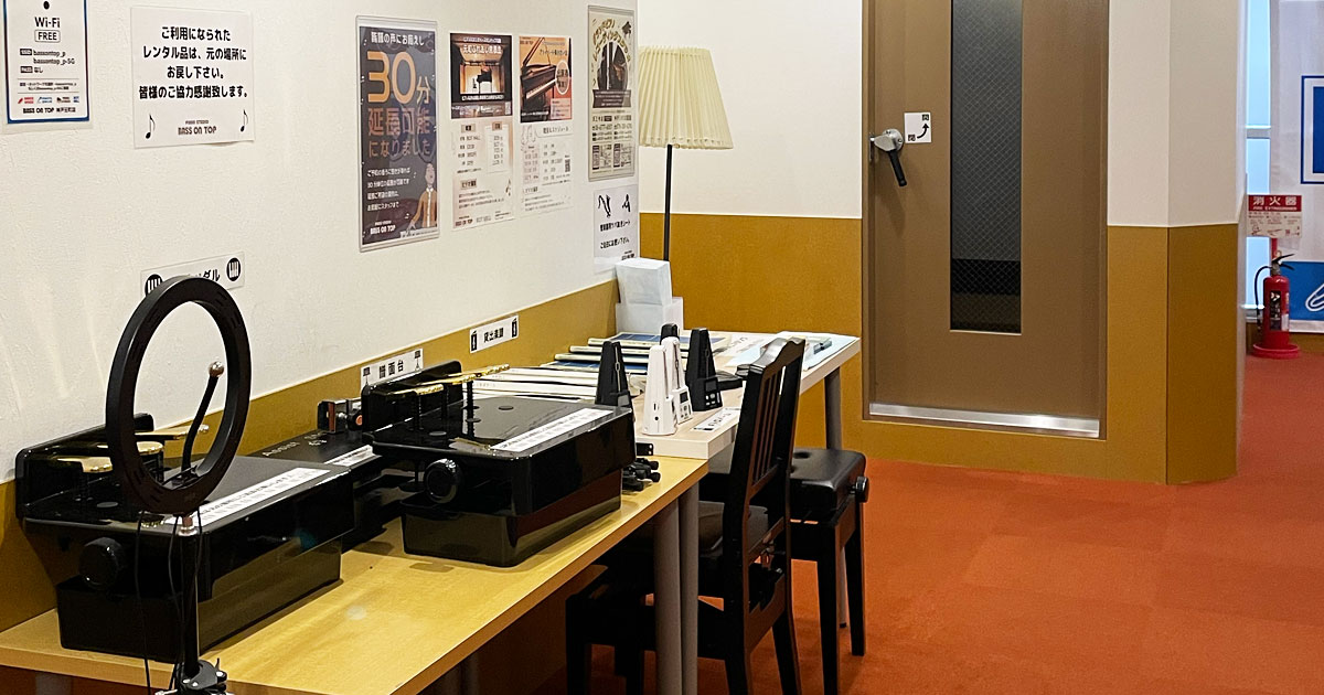 スタジオの廊下に並ぶ楽譜とピアノ用具