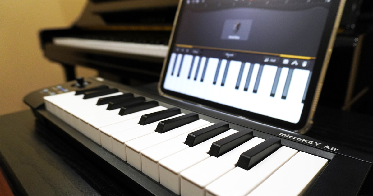 「神戸三宮のピアノ教室に設置されたアップライトピアノ、MIDIキーボード、iPad