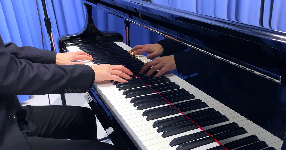 100BANスタジオにて、桑田佳祐の楽曲を演奏する際の指先と鍵盤を捉えた写真です。タッチや演奏のニュアンスが伝わるカットになっています。