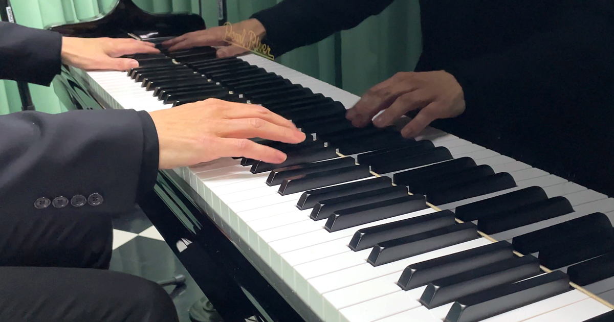 神戸市中央区・三宮の100BANスタジオで、藤澤遼が松山千春の『夢の旅人』をピアノで演奏している指先と鍵盤の様子