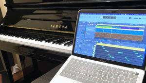 アップライトピアノとノートパソコンが並ぶ神戸・大阪のDTMレッスン用スタジオの写真