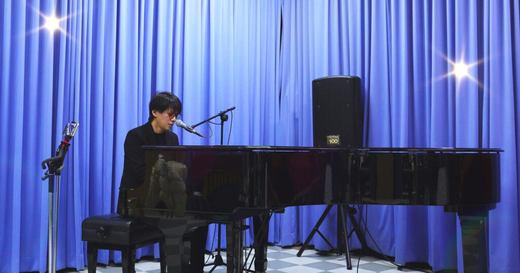 神戸市中央区・三宮の100BANスタジオで、藤澤遼が桑田佳祐の楽曲をピアノで演奏している様子